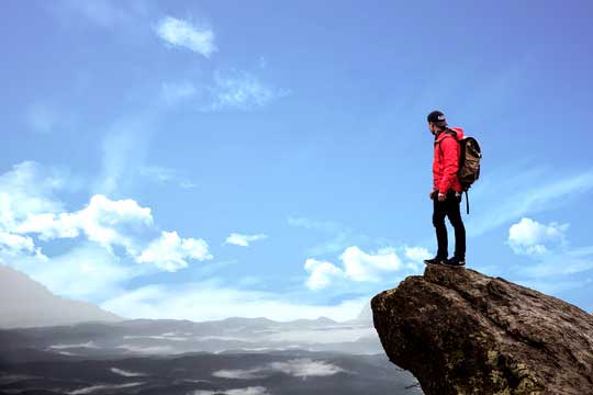 man at top of mountain motivated